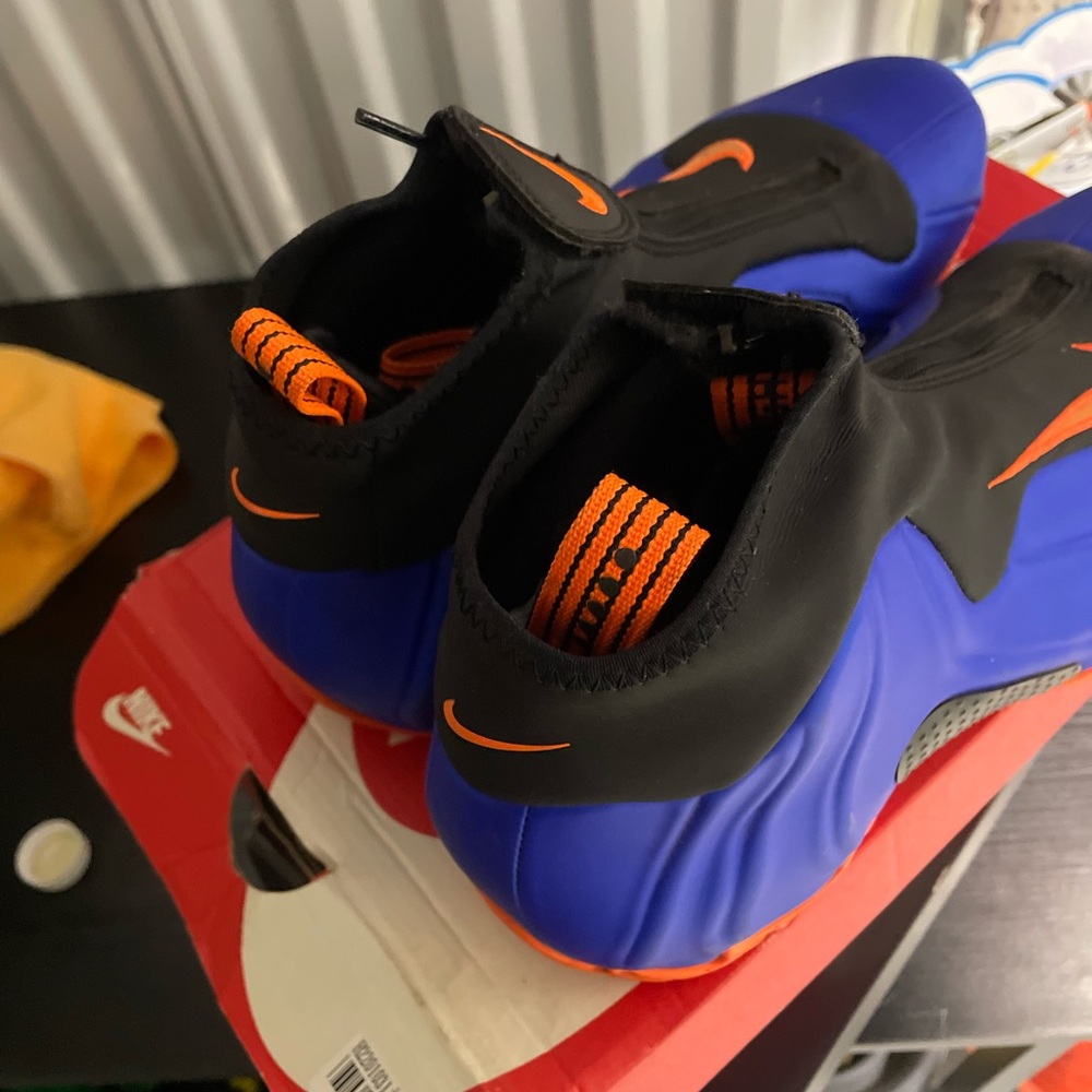 Nike Air Flightposite One Knicks Blue and Black Sneakers with Orange Accents.